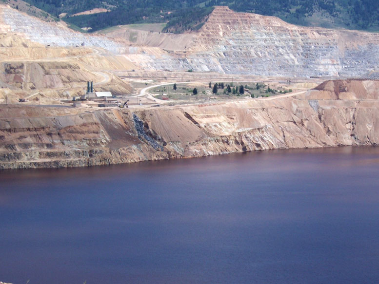The northeast rim of the Berkeley Pit in July 2013, after a Feb. 2013 slough from the Pit wall knocked out a pump used for Montana Resources copper precipitation plant. When the precipitation operation was ongoing, Berkeley Pit water was pumped to a precipitation plant where copper was removed from the water. The water was then returned to the Pit, creating the waterfall seen in past years. Photo by Fritz Daily.