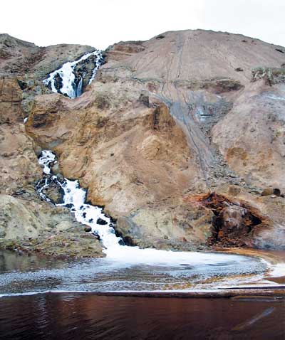 The waterfall formerly visible on the southeast rim of the Pit, seen here in 2004, created by returning Pit water that has gone through Montana Resources copper precipitation plant. Photo by Josh Peck.
